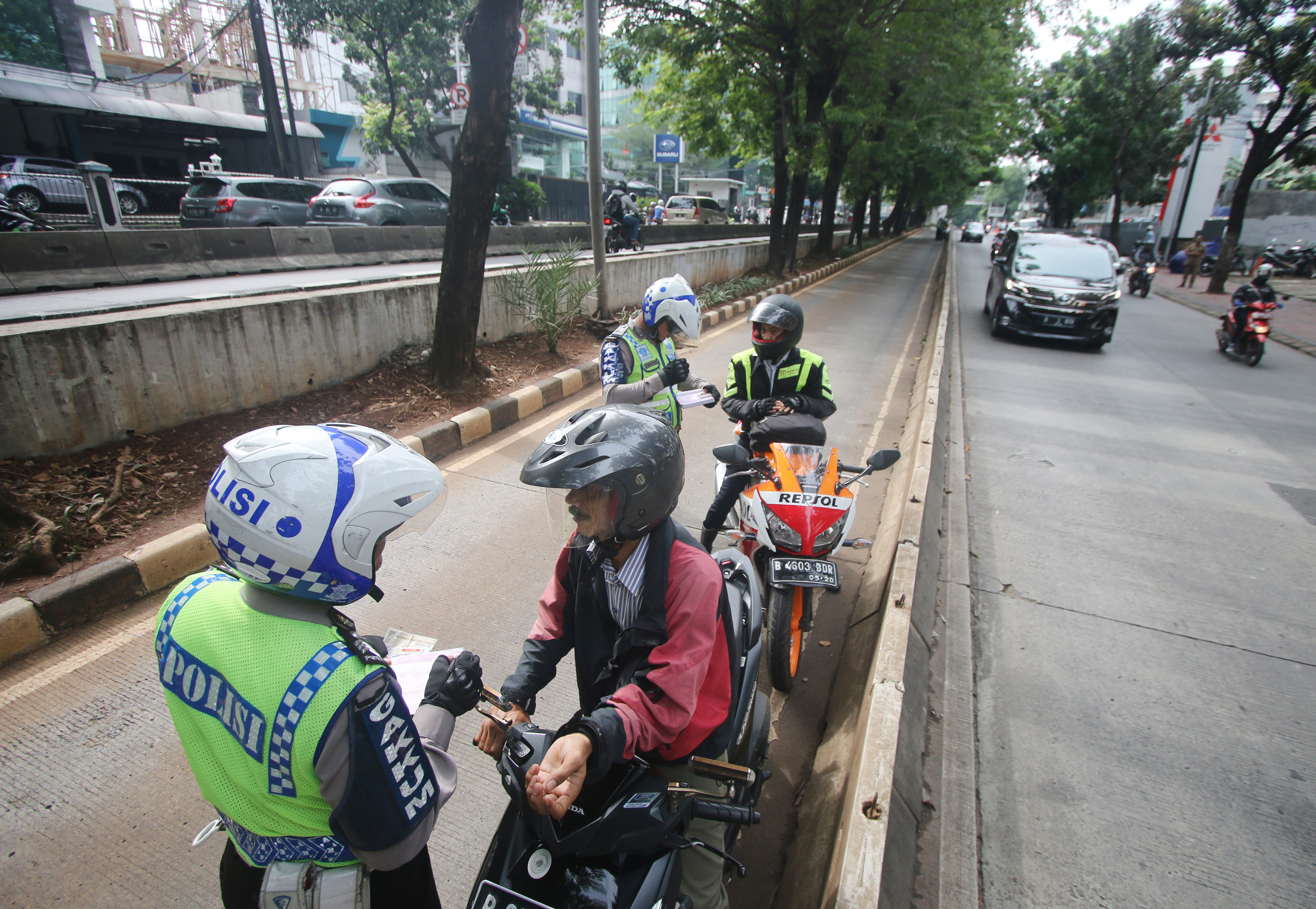 Polisi menindak pengendara sepeda motor yang masuk jalur Transjakarta di daerah arteri Pondok Indah, Jakarta. 