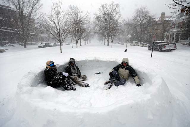 Warga duduk di hamparan salju yang menutupi median jalan di Richmond, Virginia, Amerika Serikat, Sabtu (23/1).