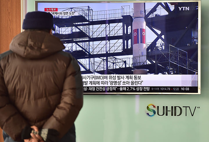 Seorang pria menonton berita di televisi tentang rencana Korea Utara (Korut) untuk meluncurkan roket balistik. Nampak dalam layar televisi menunjukkan rekaman file roket Korut Unha-3 yang diluncurkan 2012, di sebuah stasiun kereta api di Seoul (3/2/2016).