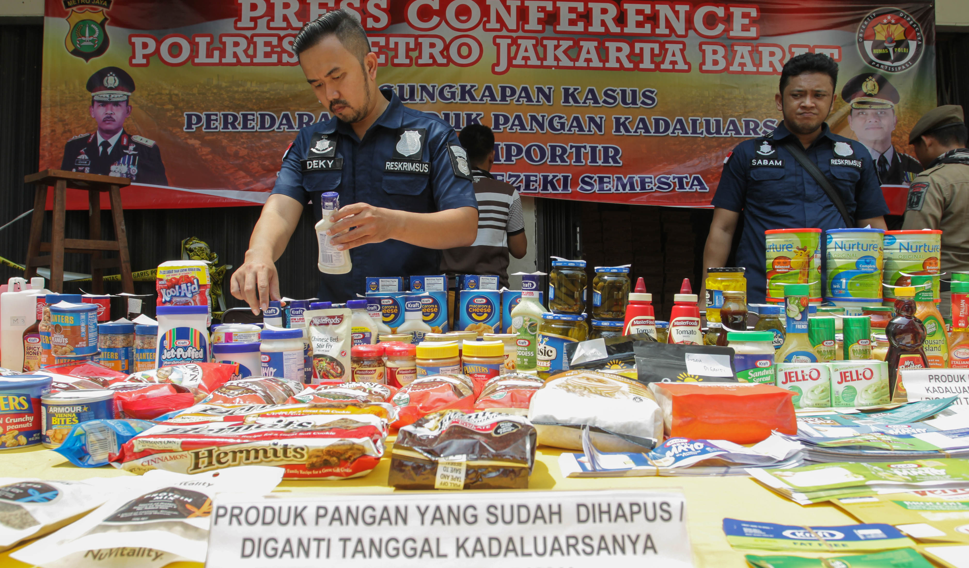 Polisi menata barang bukti seusai menggerebek gudang makanan kedaluwarsa di Tambora, Jakarta Barat, Selasa (20/3/2018)