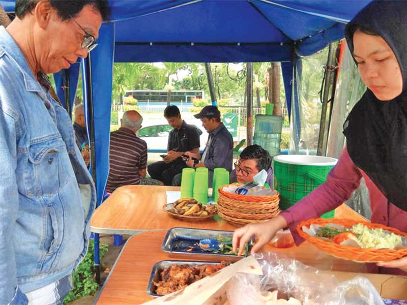 Relawan melayani konsumen di warung makan Podjok Halal di kawasan Sunter, Tanjung Priok, Jakarta Utara, Selasa (17/4/2018)