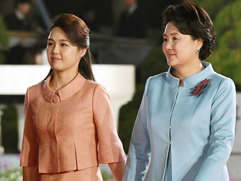 Ri Sol-ju (kiri), istri pemimpin Korea Utara Kim Jong-un, dan Kim Jung-sook , istri Presiden Korea Selatan Moon Jae-in, berjalan berpegangan tangan saat upacara perpisahan berakhirnya pertemuan KTT dua Korea, di Panmunjom, Korsel, Jumat (27/4) malam.