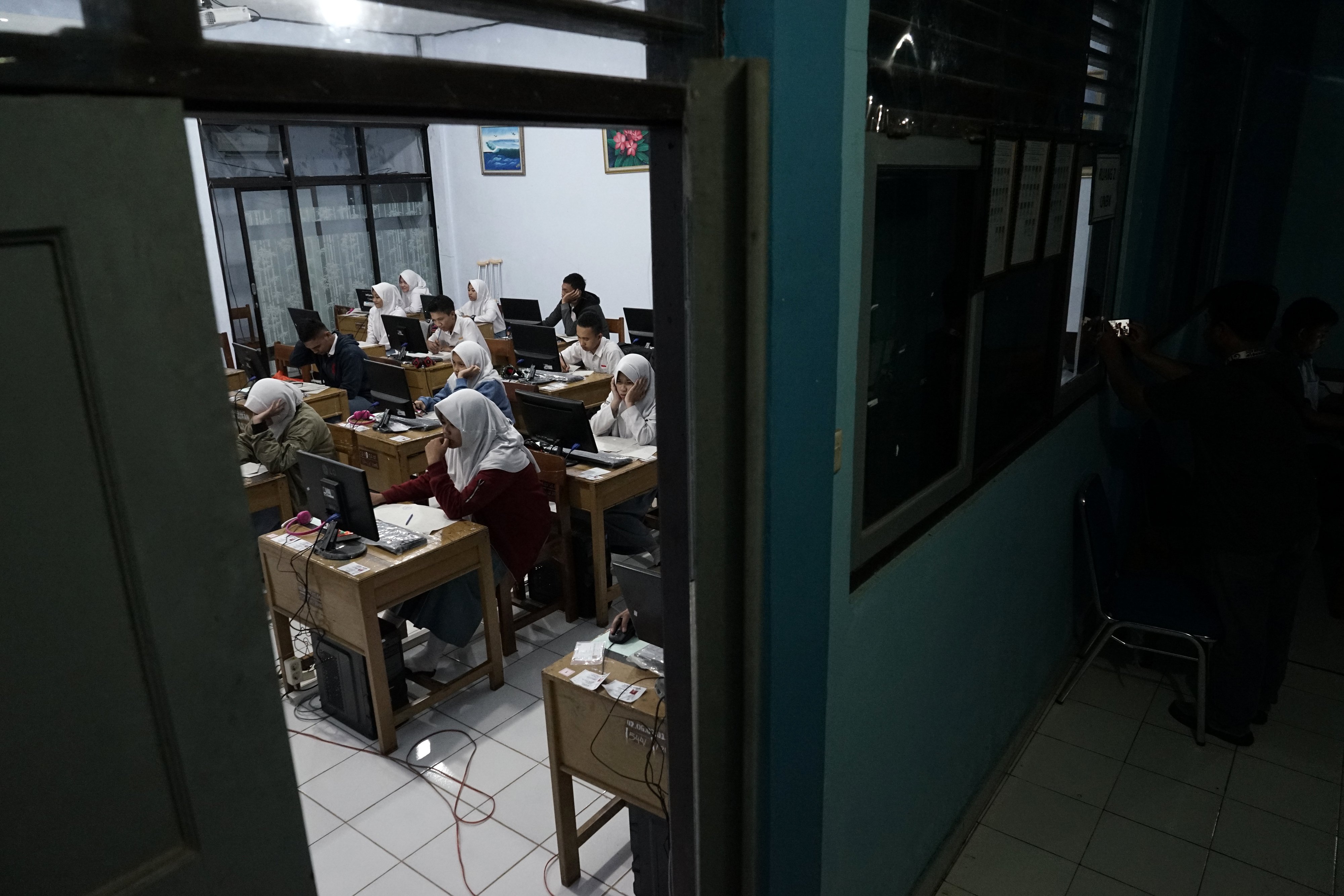 UNBK MALAM HARI: Sejumlah siswa kelas 12 mengerjakan soal ujian nasional mata pelajaran matematika pada malam hari di SMA N 2 Purbalingga, Jawa Tengah, Selasa (10/4). Sebanyak 110 siswa kelas 12 SMA N 2 Pubalingga terpaksa mengerjakan ujian nasional mata p