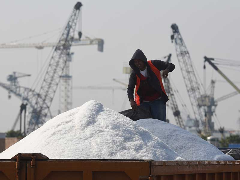 Pekerja menutupi dengan terpal garam impor yang telah dimuat truk untuk diangkut ke tempat penampungan di Pelabuhan Tanjung Perak, Surabaya, Jawa Timur, Sabtu (12/8/2017).