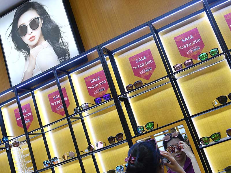 Calon konsumen mencoba kacamata saat pembukaan perdana toko Optik Winsee di Pasar Baru, Jakarta, Sabtu (31/3/2018)