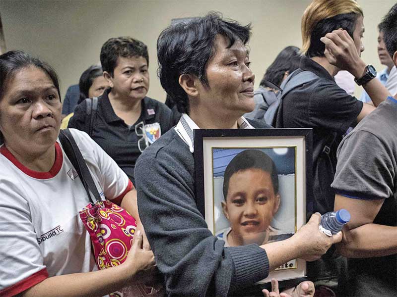 Melinda Colite memegang foto cucunya, Zandro Colite, yang meninggal diduga setelah disuntik dengan vaksin antidemam berdarah Dengvaxia di Manila, Filipina (21/2/2018)
