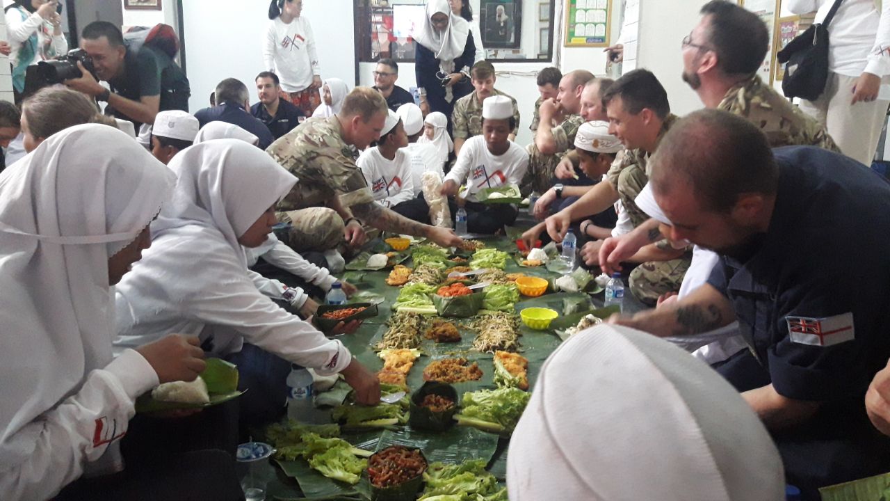 Marinir Royal British makan bersama anak Panti Asuhan Nuruz Zahroh, di Tanjung Priok, Jakarta, Minggu (22/4).
