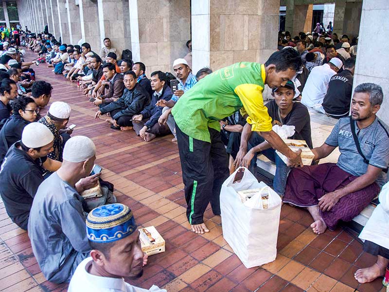 Petugas membagikan makanan menjelang waktu berbuka puasa di Masjid Istiqlal, Jakarta, Kamis (17/5/2018).