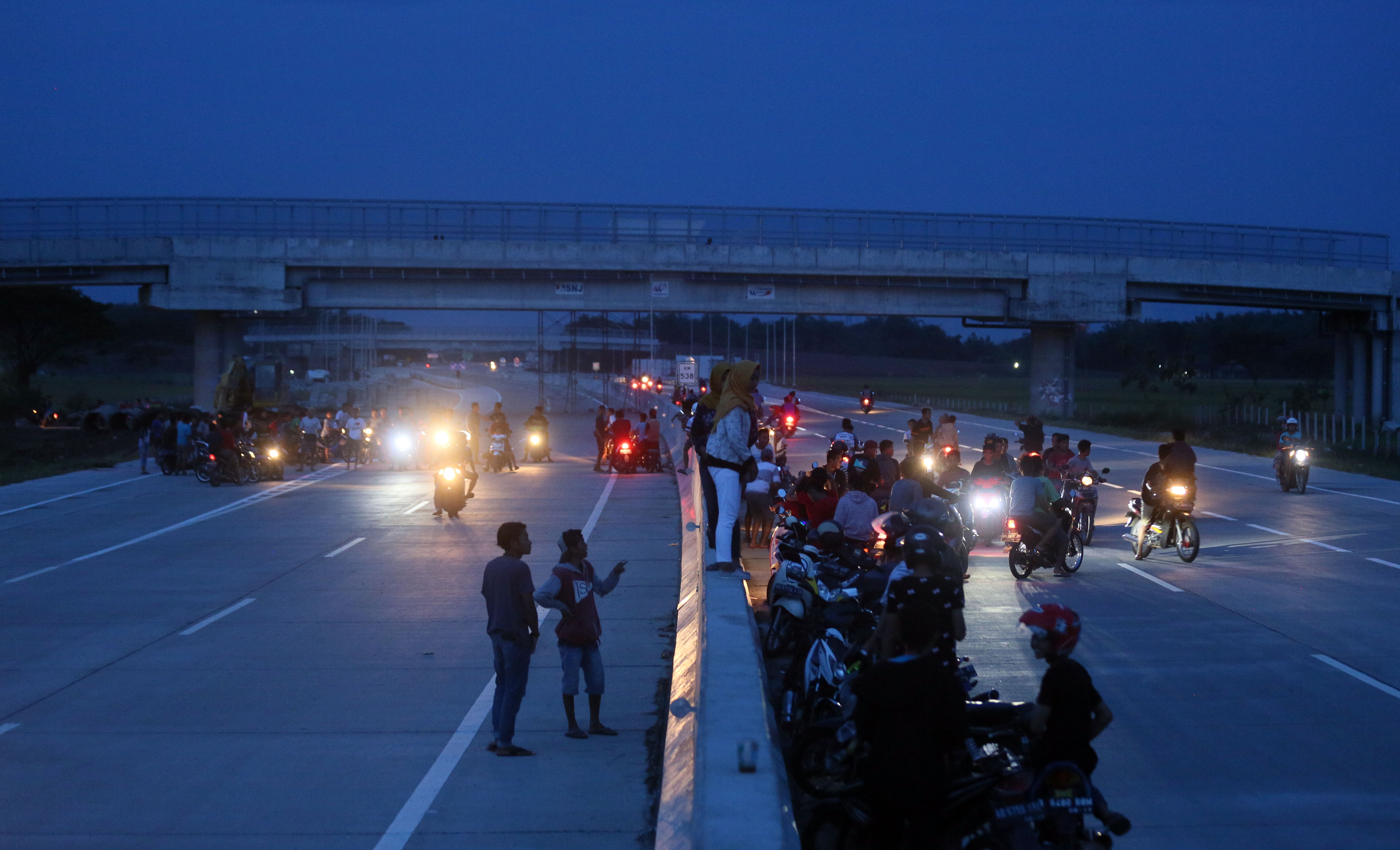 Remaja membubarkan diri seusai menyaksikan balap liar sepeda motor jelang waktu berbuka puasa di ruas Tol Solo-Kertosono (Soker) KM 537 wilayah Sragen, Jawa Tengah, Kamis (24/5).