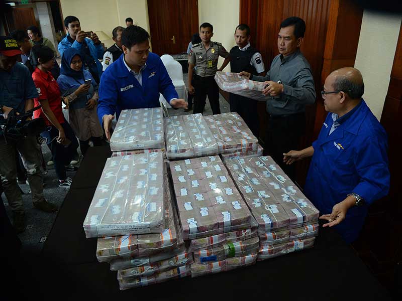  Karyawan Bank Mandiri dan Polisi menyiapkan uang ganti rugi korupsi Bantuan Likuidasi Bank Indonesia (BLBI) dengan terpidana Samadikun Hartono di Gedung Bank Mandiri, Jakarta, Kamis (17/5/2018). 