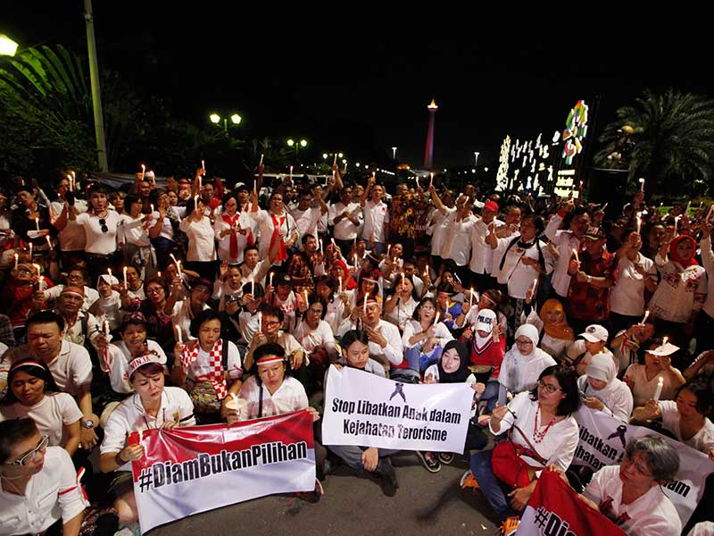 Ratusan warga yang tergabung dalam Forum Indonesia Guyub berdoa dan menyalakan lilin bersama dalam acara Solidaritas dan Doa Bersama di kawasan Monas, Jakarta, Selasa (15/5/2018)