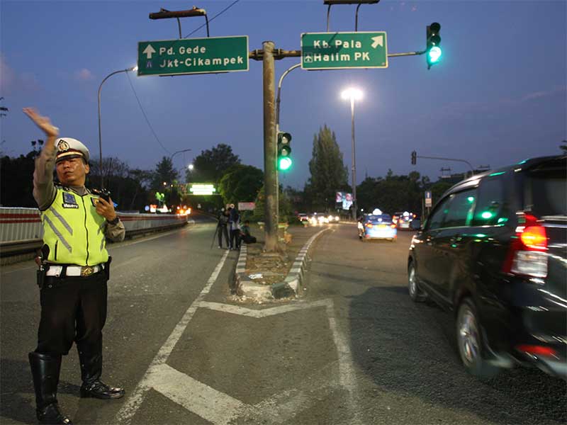 Petugas mengalihkan lalu lintas yang mengarah ke jalan tol Bekasi -Cikampek, Jakarta