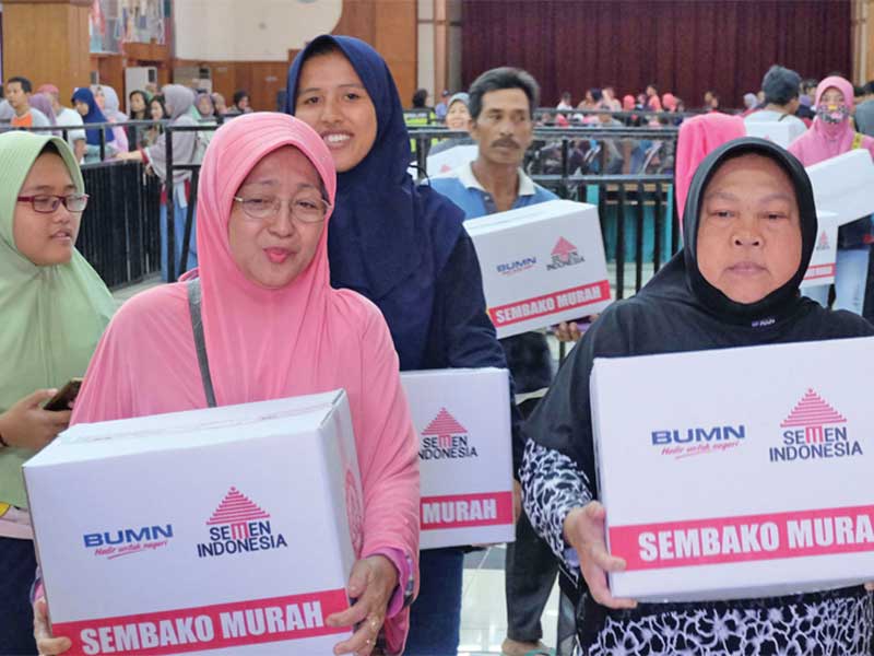 Warga membawa paket sembako yang di beli saat gelaran pasar murah yang diselenggarakan Semen Indonesia dan Ikatan Istri Karyawan Semen Indonesia (IIKSMI) di Wisma A Yani, Gresik, Jawa Timur, Senin (11/6/2018)