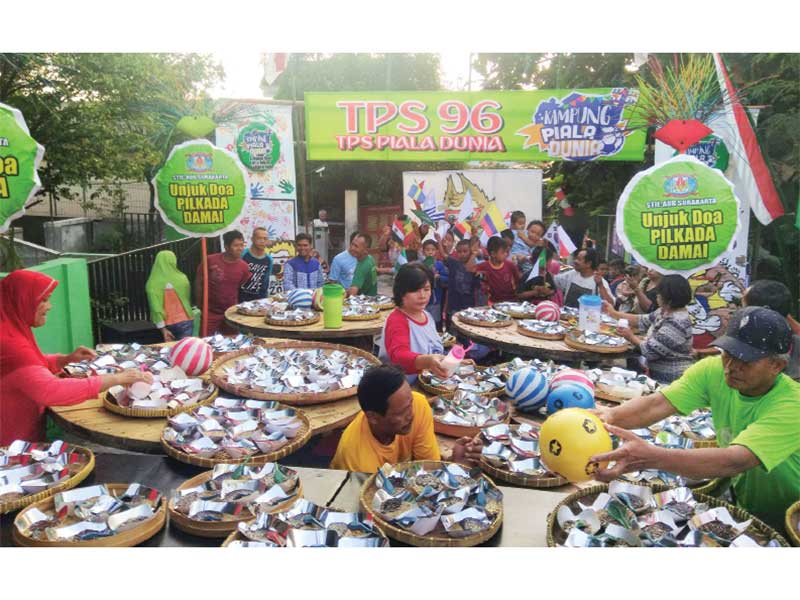 TPS BERNUANSA PIALA DUNIA: Warga membuat tempat pemungutan suara (TPS) pilkada bertema Piala Dunia 2018 di Kampung Dukuhan Nayu, Kelurahan Kadipiro, Surakarta, Jawa Tengah, kemarin. Berlangsungnya Piala Dunia 2018 dimanfaatkan warga untuk menarik minat mas