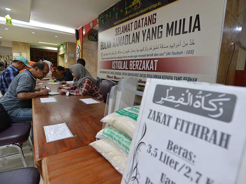 Umat muslim membayarkan zakat fi trah kepada panitia amil zakat di Masjid Istiqlal, Jakarta, Senin (11/6/2018).