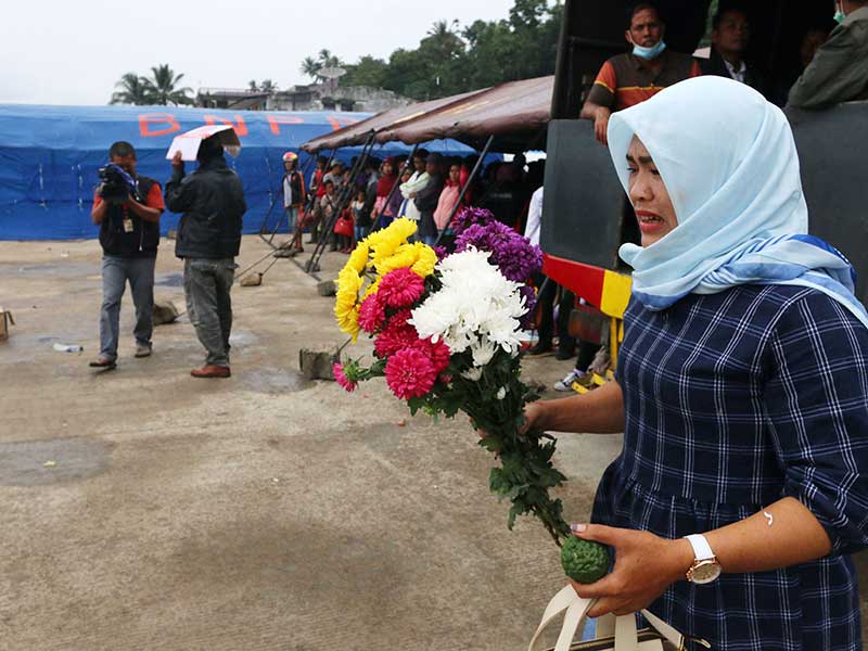  Hotna Saragih (38) salah satu penumpang KM Sinar Bangun yang selamat, menangis saat akan menaburkan bunga di Danau Toba, di Pelabuhan Tigaras, Simalungun, Sumatera Utara, Kamis (21/6/2018). 