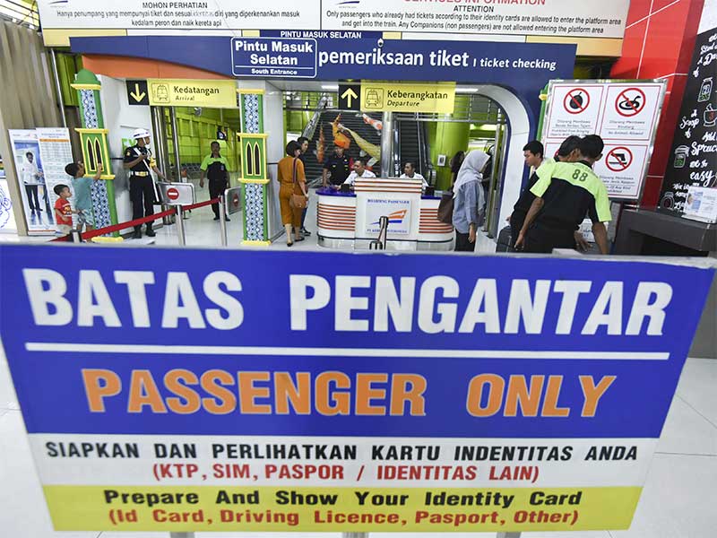 Calon penumpang kereta api melewati pintu pemeriksaan identitas di Stasiun Gambir, Jakarta