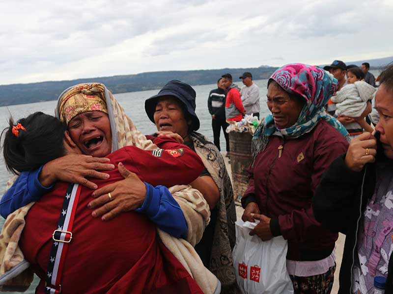Keluarga penumpang menangis saat menyaksikan proses pencarian penumpang KM Sinar Bangun yang tenggelam di Danau Toba, Simalungun, Sumatra Utara, Selasa (19/6/2018). 