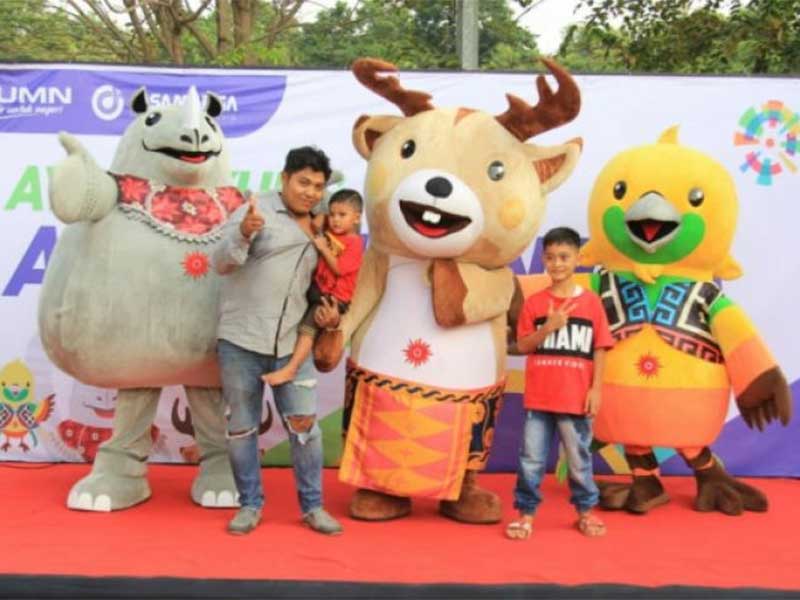 Pemudik memanfaatkan acara sosialisasi Asian Games untuk berfoto dengan maskot 