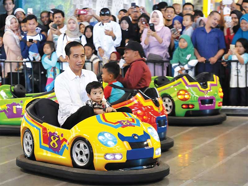 Presiden Joko Widodo bersama cucunya, Jan Ethes, naik bumper car saat mengisi liburan Lebaran di wahana permainan anak di pusat perbelanjaan Transmart Yasmin, Kota Bogor, kemarin. Kedatangan presiden menjadi perhatian pengunjung, mereka antusias untuk bers