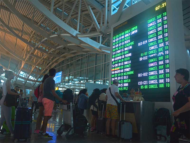 Sejumlah penumpang mencari informasi jadwal penerbangan di Bandara Ngurah Rai, Bali