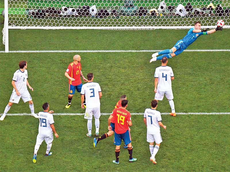 Penjaga gawang timnas Rusia Igor Akinfeev berusaha menangkap bola dari tendangan pemain Spanyol dalam laga babak 16 besar Piala Dunia 2018 di Stadion Luzhniki, Moskow, Rusia, Minggu (1/7/2018)