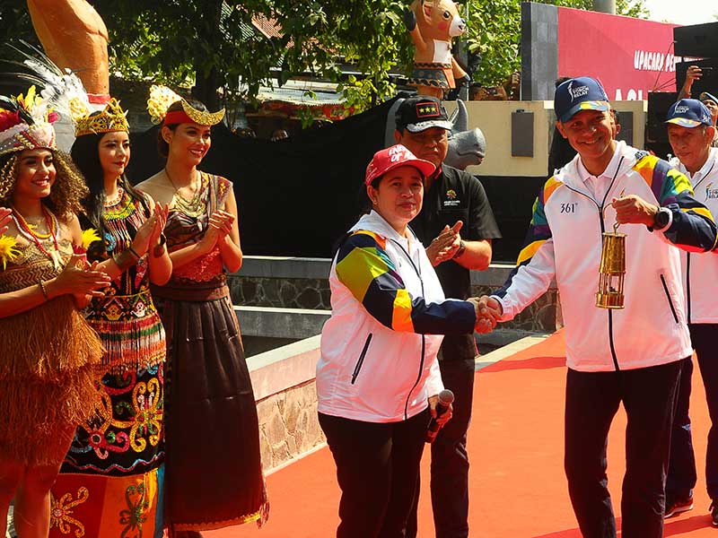  Menteri Koordinator Bidang Pembangunan Manusia dan Kebudayaan Puan Maharani (tengah) menyerahkan tinder box yang berisi api kepada Gubernur Jawa Tengah Ganjar Pranowo (kanan) saat pengambilan api atau obor Asian Games di Mrapen, Grobogan, Jawa Tengah, Rab