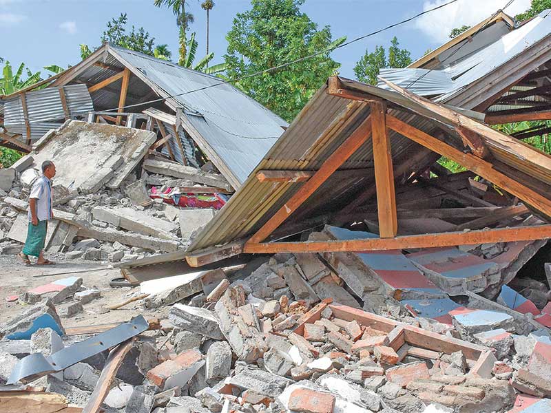 Warga melihat rumah yang ambruk akibat diguncang gempa berkekuatan 6,4 pada skala Richter (SR) di Desa Sajang, Sembalun, Selong, Lombok Timur, Nusa Tenggara Barat, Minggu (29/7/2018)