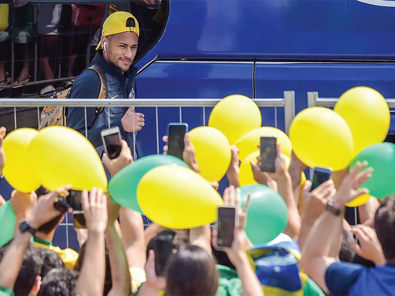 Bintang tim nasional Brasil Neymar mengacungkan jempol saat disambut para suporter Brasil yang menunggu kedatangannya di Hotel Mirage, Kazan, Rusia, kemarin. Brasil akan berhadapan dengan Belgia pada babak perempat fi nal Piala Dunia 2018 di Kazan Arena, K