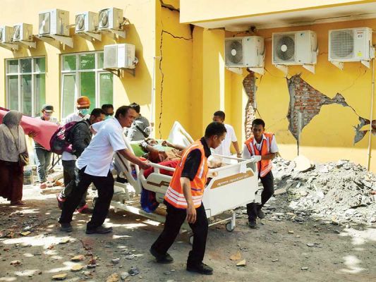 EVAKUASI PASIEN: Petugas memindahkan pasien untuk menjalani perawatan di bagian luar Rumah Sakit Moh Ruslan di Mataram, NTB, kemarin. Berdasarkan data dari BNPB, gempa berkekuatan 7 pada skala Richter yang mengguncang Lombok, Sumbawa, dan Bali pada Minggu 