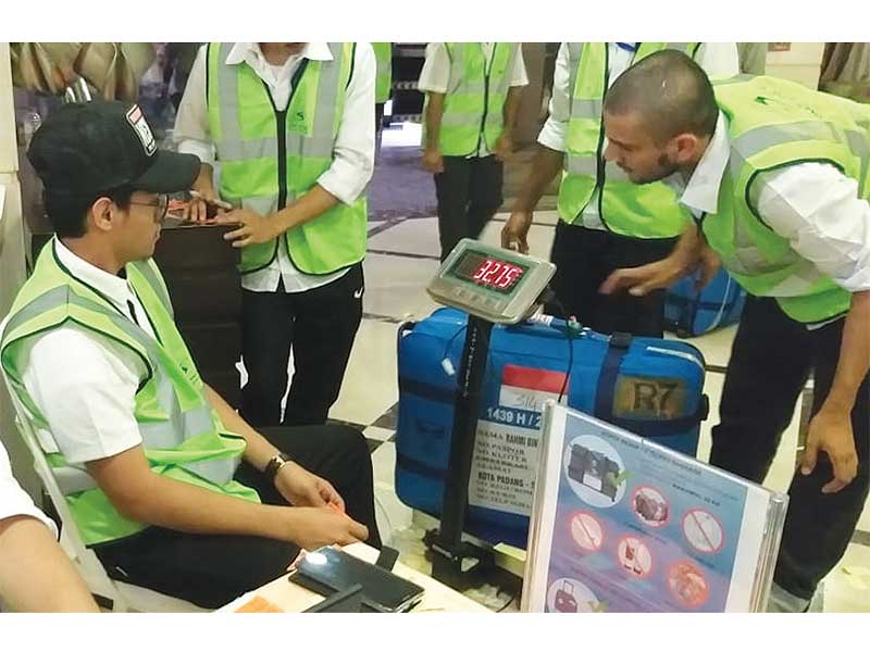 TIMBANG KOPER: Petugas dari maskapai Garuda Indonesia menimbang koper jemaah dari Padang, Sumatra Barat, (SOC 01) di Kiswah Tower, Jarwal, Mekah, Arab Saudi, kemarin. Sebanyak 13 kloter atau 5.391 jemaah gelombang 1 akan dipulangkan ke Tanah Air pada hari 