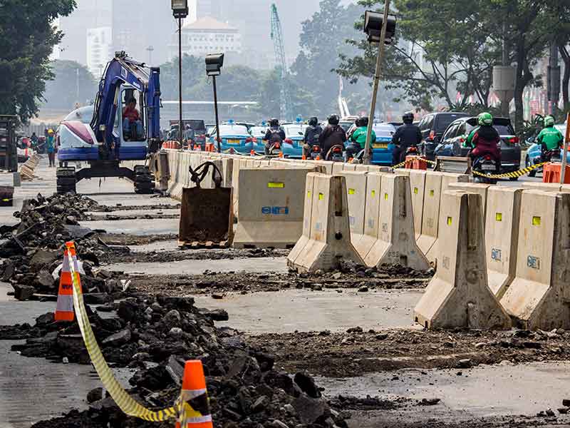 Pekerja menyelesaikan pekerjaan penataan jalur pedestrian di kawasan jalan Sudirman, Jakarta, Selasa (10/7/2018)