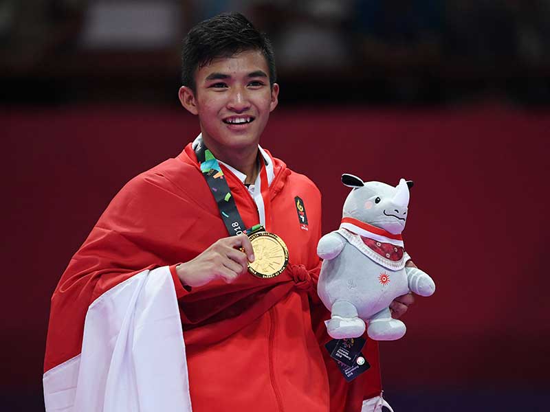 : Karateka Indonesia Rifki Ardiansyah Arrosyiid memegang medali emas yang diperolehnya setelah mengalahkan karateka Iran, Amir Mahdi Zadeh pada final karate putra 60kg pada Asian Games 2018 di JCC-Plenary Hall Senayan, Jakarta, Sabtu (25/8/2018)