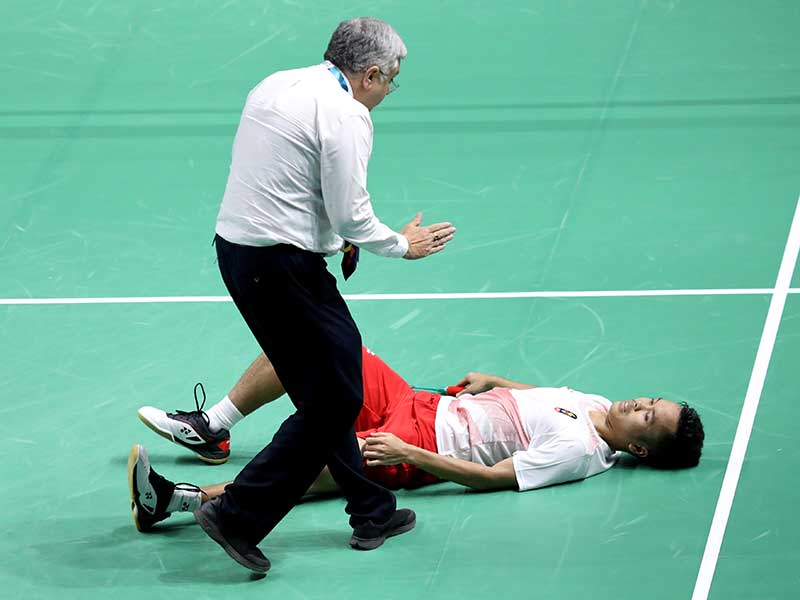  Wasit menghampiri pebulu tangkis tunggal putra Indonesia Anthony Sinisuka Ginting yang mengalami cedera saat melawan pebulu tangkis tunggal putra Cina Shi Yuqi pada set ketiga babak final beregu putra Asian Games 2018 di Istora Senayan, Jakarta, Rabu (22/