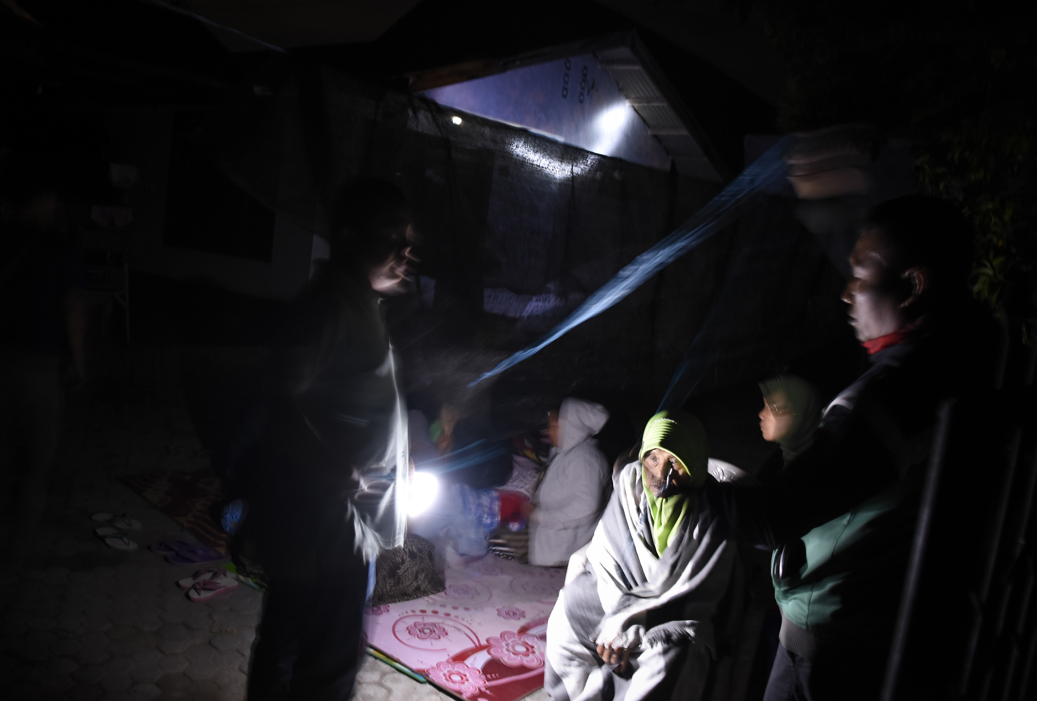 LOMBOK KEMBALI DIGUNCANG GEMPA: Warga membuat tenda dan memilih tetap berada di luar rumah pascagempa di Ampenan, Mataram, NTB, Minggu (19/8). Gempa bumi berkekuatan 7 Skala Richter kembali mengguncang Lombok pada Minggu malam pukul 22.56 Wita yang berpusa