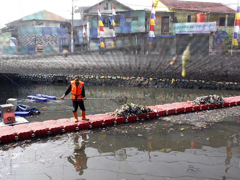  Petugas PPSU membersihkan dan mengangkut sampah Kali Sentiong Atau Kali Item yang telah dipasangi waring di Kemayoran, Jakarta Pusat, Sabtu (11/8/2018). 