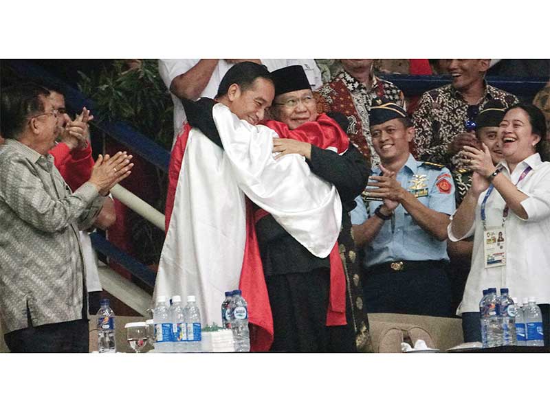 SELEBRASI YANG MENYEJUKKAN: Pesilat Hanifan Yudani Kusumah dengan berbalut bendera Merah Putih memeluk Presiden Joko Widodo dan Ketua Umum Pengurus Besar Ikatan Pencak Silat Indonesia (IPSI) Prabowo Subianto setelah mengalahkan pesilat Vietnam Thai Linh Ng