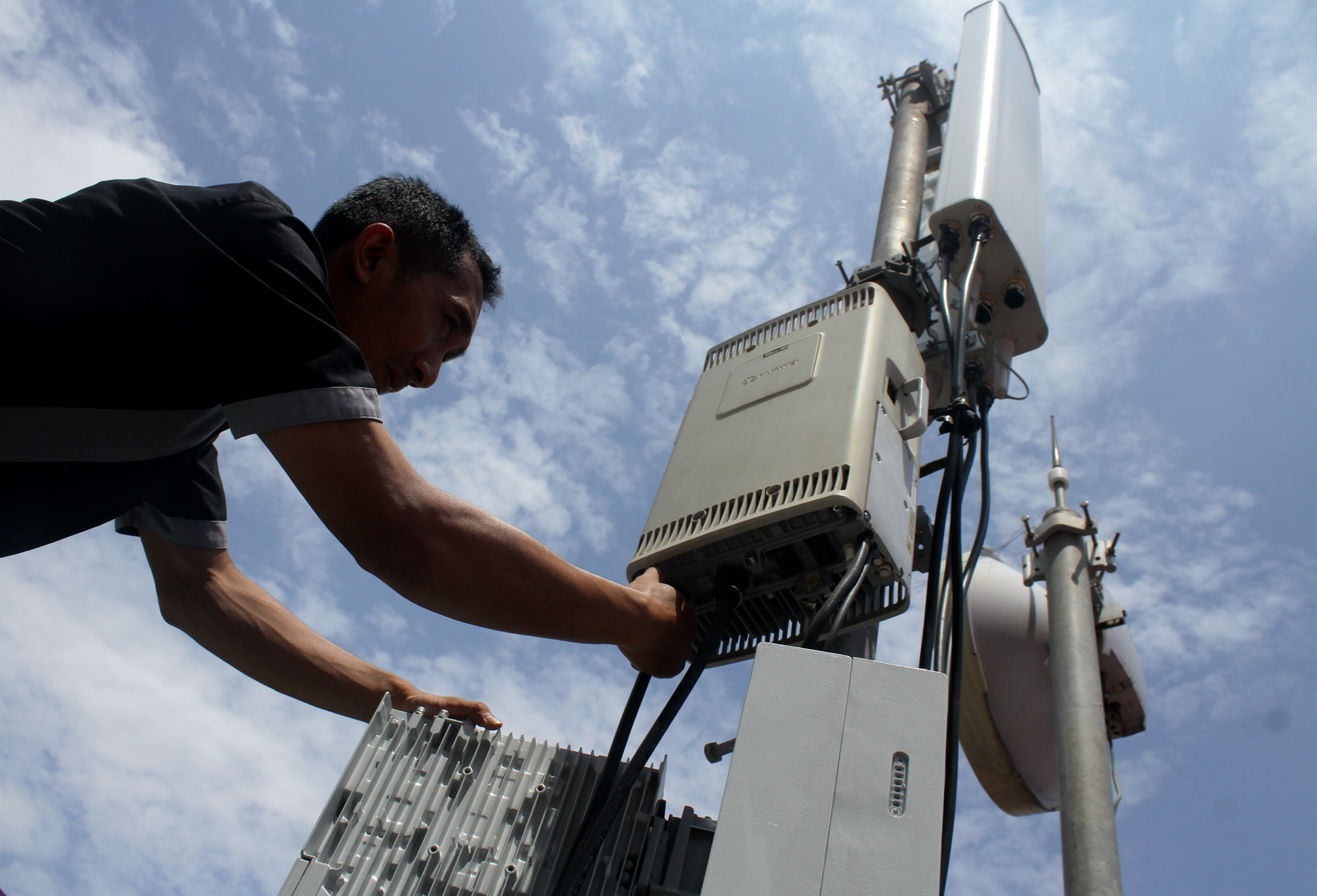  Petugas memperbaiki antena sektor penerima dan pemancar sinyal ponsel 4G 