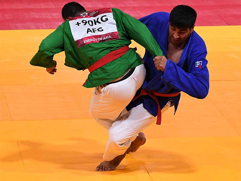 Atlet kurash Uzbekistan Nurbek Turaex (kanan) melakukan serangan pada atlet kurash Afganistan Abdul Basir Rahmani (kiri) saat bertanding pada babak perempat final putra -90kg Asian Games 2018 di Assembly Hall JCC Senayan, Jakarta, Selasa (28/8). 