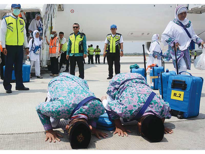 TIBA DI TANAH AIR: Jemaah haji kloter I dari Tegal yang baru saja turun dari pesawat Garuda Indonesia melakukan sujud syukur di landasan Bandara Adi Soemarmo, Boyolali, Jawa Tengah, kemarin. Sebanyak 360 jemaah haji kloter I asal Kabupaten Tegal tiba kemba