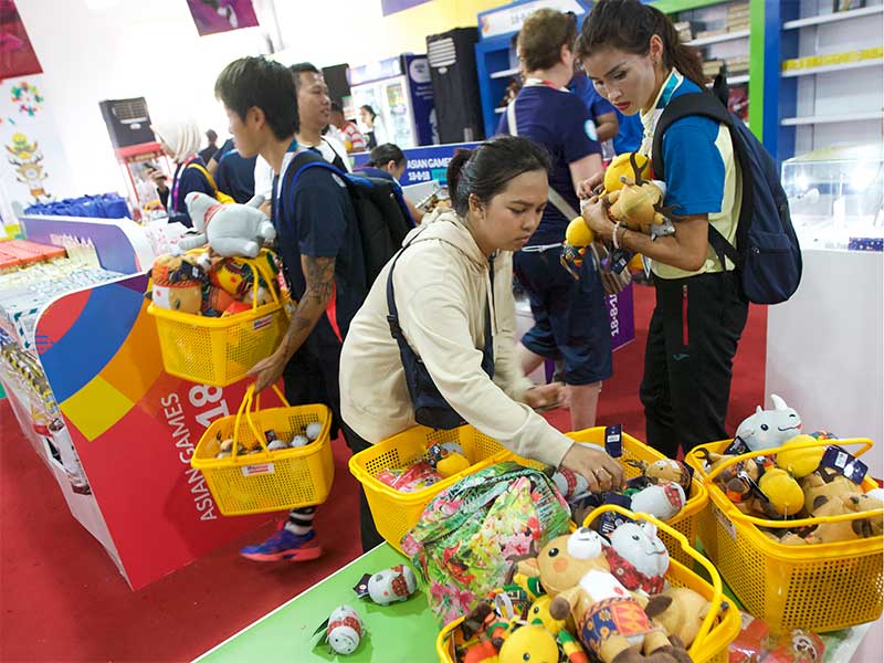 Warga berebut membeli souvenir di toko resmi Asian Games 2018 di kawasan Gelora Bung Karno, Jakarta, Rabu (29/8). Teriknya matahari tak menyurutkan semangat masyarakat untuk berburu souvenir Asian Games 2018, bahkan sebagian dari mereka rela antre sejak pa