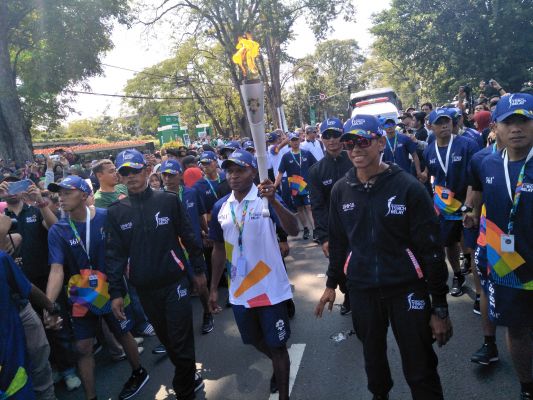 Mantan anggota tim nasional sepakbola Alexander Pulalo membawa Obor Asian Games 2018 di Bandung, Sabtu (11/8).