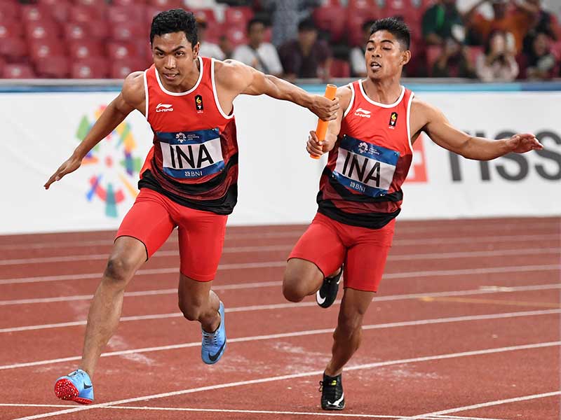 Pelari Indonesia Fadlin (kanan) menyerahkan tongkat kepada Lalu Muhammad Zohri pada babak penyisihan Lari Estafet 4x100m Putra Asian Games ke-18 Tahun 2018 di Stadion Utama Gelora Bung Karno Senayan, Jakarta, Rabu (29/8/2018)