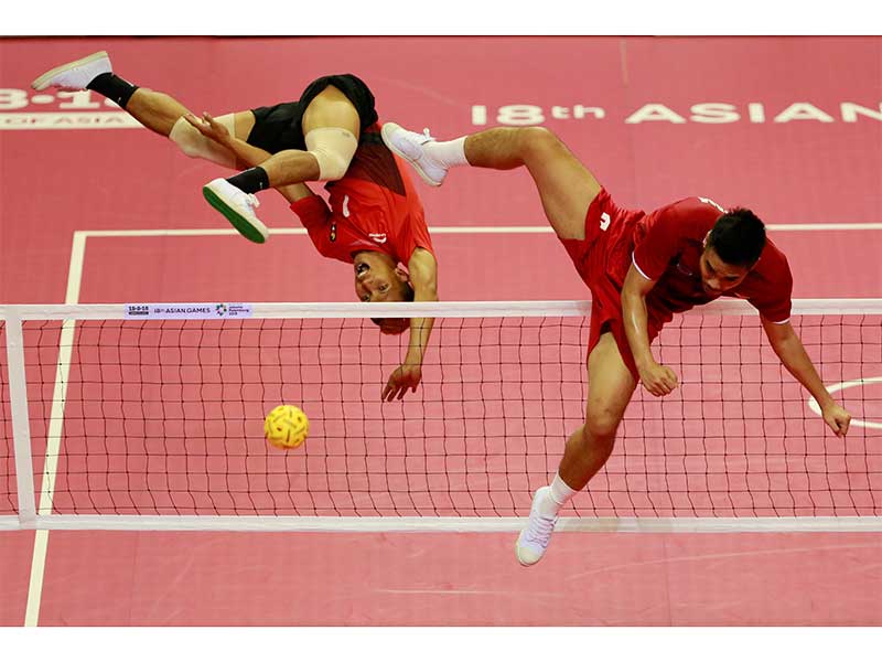 Pemain sepa ktakraw putra Indonesia, Mohamad Herson Saipul (kiri) menendang bola ke arah pemain Vietnam Hoang Lan Nguyen (kanan) saat pertandingan penyisihan ganda putra sepak takraw Asian Games 2018 di GOR Ranau, Jakabaring Sport City (JSC), Palembang, Su