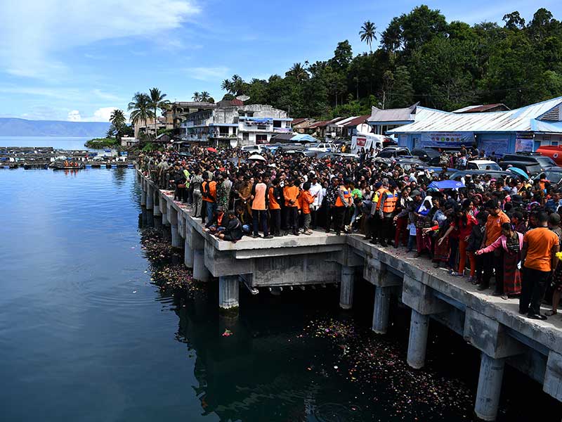 Keluarga korban tenggelamnya KM Sinar Bangun menabur tabur bunga di Dermaga Tigaras, Danau Toba, Simalungun, Sumatera Utara, Selasa (3/7/2018). 