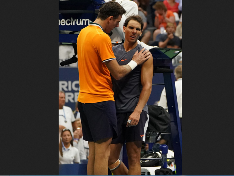 Juan Martin Del Potro menghibur Rafael Nadal setelah petenis Spanyol itu memutuskan mengundurkan diri di laga semifinal AS Terbuka.