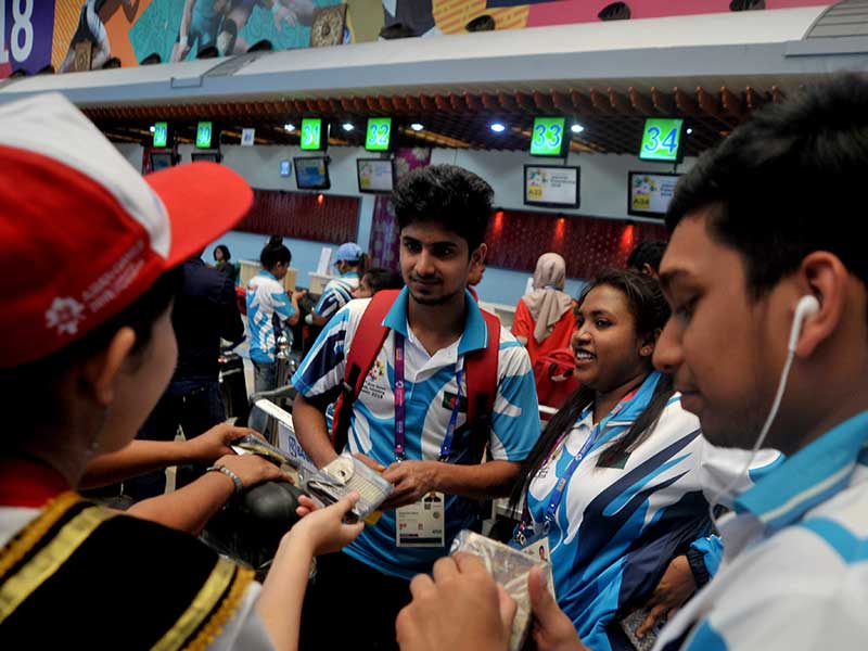  Petugas Angkasa Pura II membagikan aneka souvenir pada para atlet dan official yang akan pulang di Bandara Sultan Mahmud Badaruddin II Palembang,Sumsel