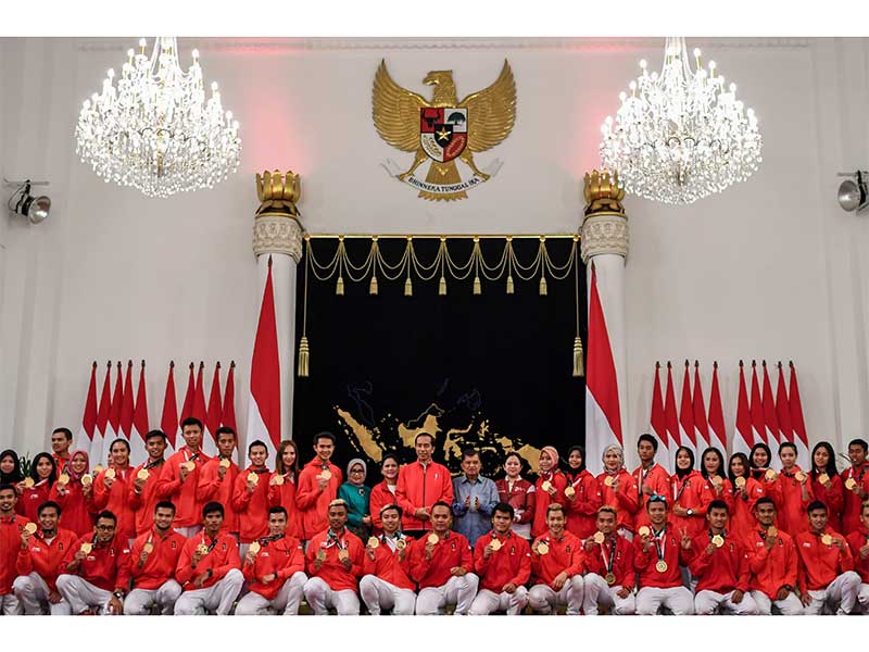 Presiden Joko Widodo (tengah) didampingi Ibu Negara Iriana Joko Widodo (kedua belas kiri), Wakil Presiden Jusuf Kalla (ketiga belas kanan), Ibu Mufidah Jusuf Kalla (sebelas kiri) dan Menko PMK Puan Maharani (kedua belas kanan) berfoto bersama atlet peraih 