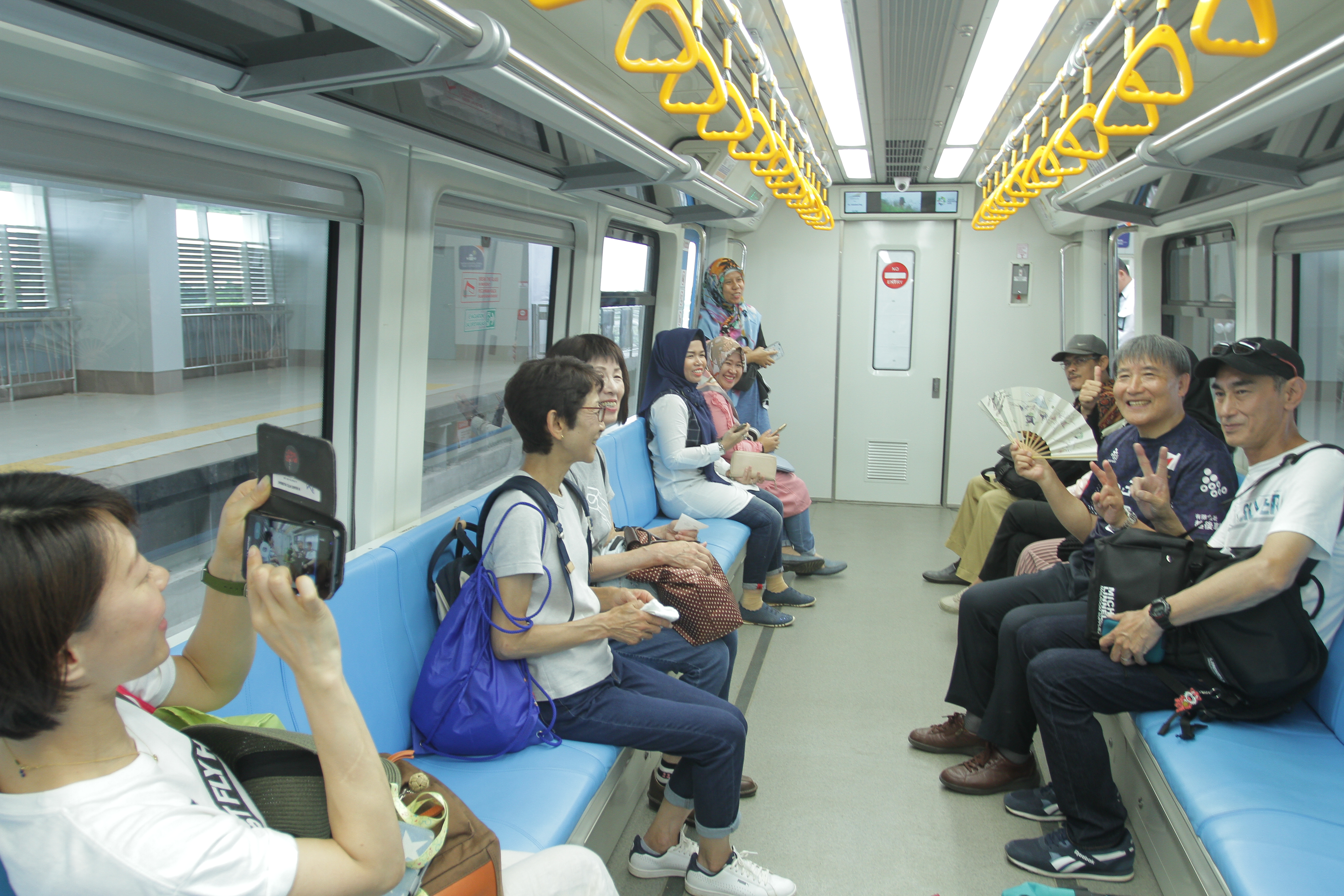Kontingen Jepang menyempatkan diri berfoto dengan latar LRT Palembang, saat raun-raun dengan LRT antara Jakabaring, DJKA, lalu ke pusat kota, Jumat (31/8).