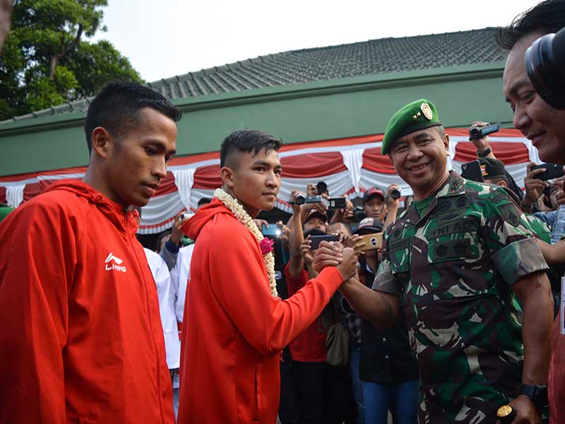 Pangdam V/Brawijaya, Mayjen TNI Arif Rahman (kedua kanan) menyalami atlet karate peraih medali emas Asian Games 2018 Serda Rifki Ardiansyah Arrosyiid (kedua kiri) dan atlet lari halang rintang 3.000 meter Sertu Atjong Tio Purwanto (kiri) yang tiba di Marka
